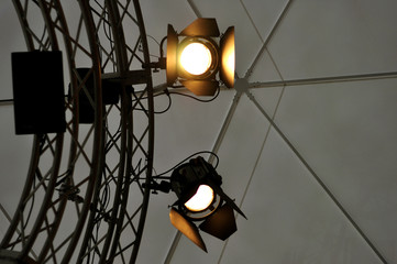 Professional lighting equipment near ceiling of theater stage.