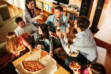 Group of young friends eating pizza.Home party.