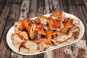 Plexiglas foto achterwand Plateful of Spit Roasted Pork Shoulder Slices Set on Old Cracked Flaky Wooden Garden Table © buki77