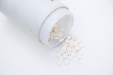 pills with medicine pill bottle close-up on a white background