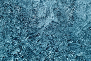 Frozen window with icy textured pattern, glass surface cracked ice macro view, soft focus shallow depth of field. cold weather concept