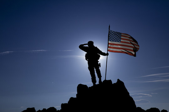 soldier on top of a mountain with a USA flag