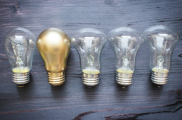 Illuminated light bulb in a row of dim ones concept for creativity, innovation and solution