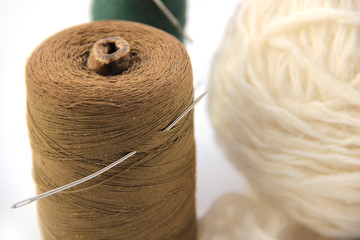 a group of multi-colored balls of yarn and knitting needles