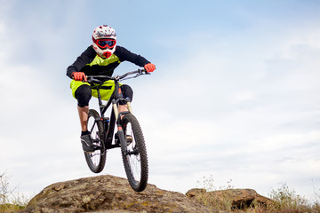 Professional Cyclist Riding the Bike Down Rocky Hill. Extreme Sport Concept. Space for Text.