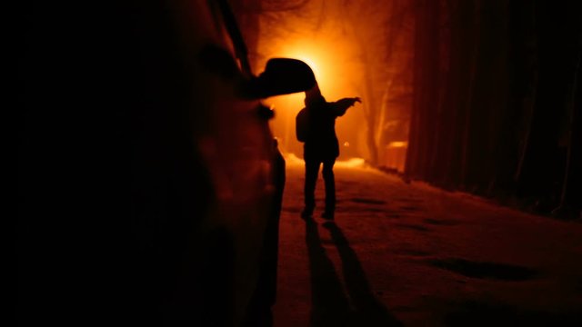 Silhouette terrible zombie night near the car