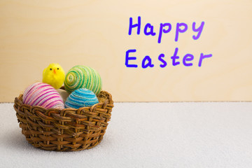 Yellow Easter chick and basket of Easter eggs