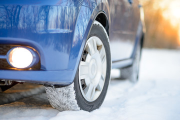 Blue Car with Winter Tires on the Snowy Road. Drive Safe.