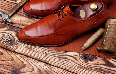 Fashion derby shoes handmade and shoemaker tools awl, nails, skien of thread .Wooden background.copy space.top view.Concept cobbler