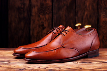 Fashionable leather derby shoes for men on wooden background