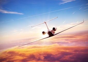 Fototapeta premium Private jet plane flying above clouds