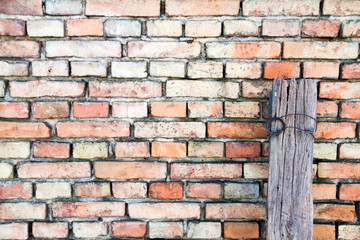 Brick wall and a wooden pole in a close up