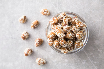 Caramel Coated Peanut with Sesame on Stone Background