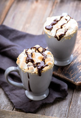 S'mores drink. Two mugs of hot chocolate with marshmallows on a wooden table. Cocoa.
