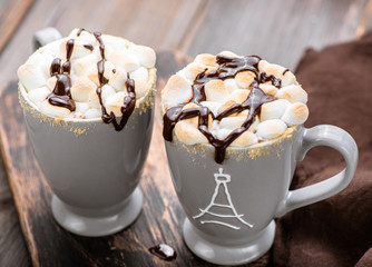 S'mores drink. Two mugs of hot chocolate with marshmallows on a wooden table. Cocoa.