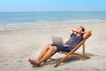 freelancer with laptop on the beach, successful happy business man relaxing, freelance work