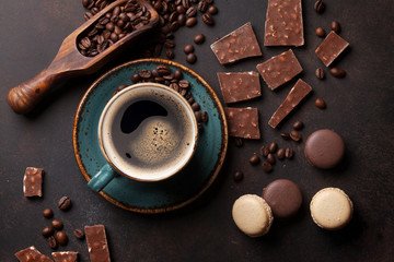 Coffee cup, chocolate and macaroons on old kitchen table