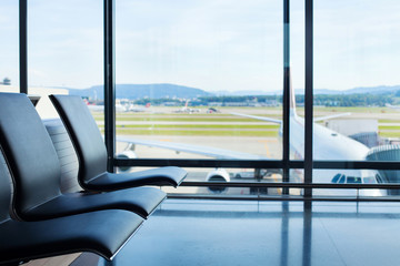 luchthaven achtergrond, stoelen in wachtlounge en vliegtuig in het raam, interieur
