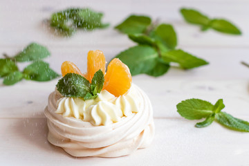 Pavlova meringue cake with fresh berries and mint on white background.