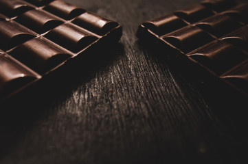 chocolate on wooden table on dark background