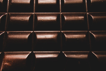 chocolate on wooden table on dark background