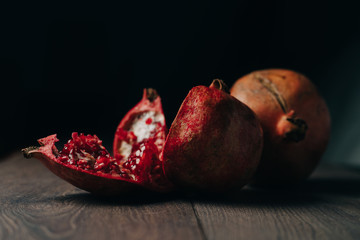 red juicy pomegranate, wooden background, fruit