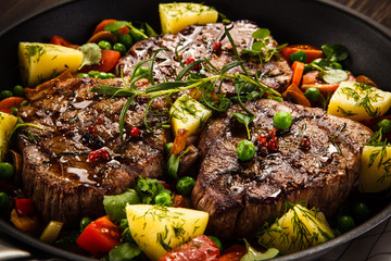 Grilled steak, baked potatoes and vegetables