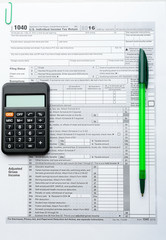 Green pen and calculator on tax form