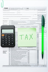 Naklejka na ściany i meble Green pen and calculator on tax form