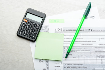 Green pen and calculator on tax form