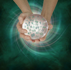 Lucky Lottery Numbers 1 to 59 - female hands cupped around a large crystal ball with random lottery...