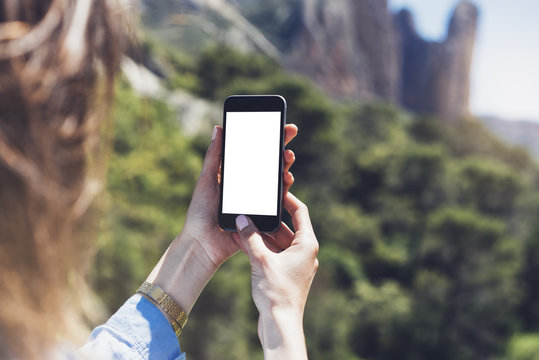Hipster girl making photo on smartphone mobile closeup, view tourist hands using gadget phone in travel on background mountains landscape; finger touch screen cellphone mockup nature, templates