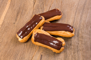 Eclairs traditional homemade French cuisine with chocolate on wo