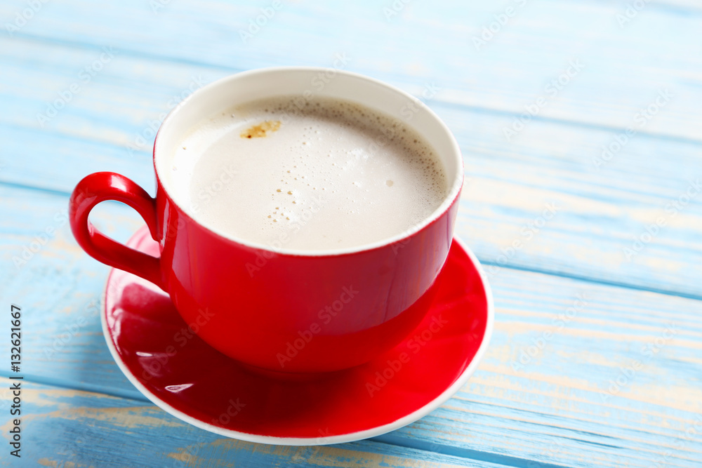 Wall mural cup of coffee on a blue wooden table