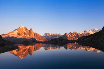 Schilderijen op glas prachtige natuur achtergrond, berglandschap bij zonsondergang, panoramisch uitzicht op de Alpen met reflectie in het meer © Song_about_summer