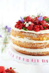 Delicious biscuit cake with berries on cake stand