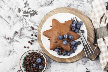 Homemade baking. Chocolate Biscuit star with a fresh blueberry and  drops. Top view. Flat lay