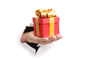 Male hand with gift box punching through the paper