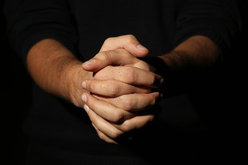 Male hands on a black background