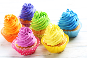 Tasty cupcakes on a white wooden table