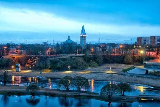 Narva. Estonia. Night view of the city with beach on Narova River and Alexander Lutheran Cathedral