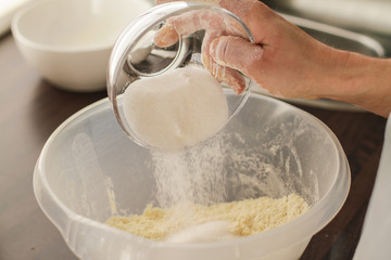 Adding Sugar into a fresh Dough mix on the table