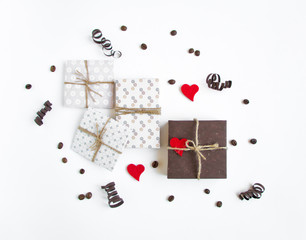 Rustic handmade gift boxes on white background decorated with hearts and paper serpentine. Top view, flat lay