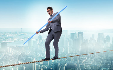 Businessman doing tightrope walking in risk concept