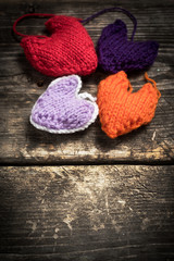 Valentine's Day. Colorful knitted hearts. Red heart on the dark old boards. Valentines day. Heart...