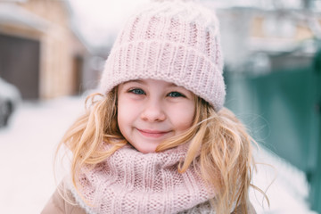 Winter portrait of smile child girl in hat and scarf