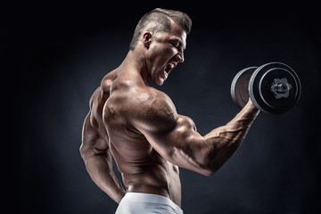 Muscular bodybuilder guy doing exercises with dumbbell - 132626088