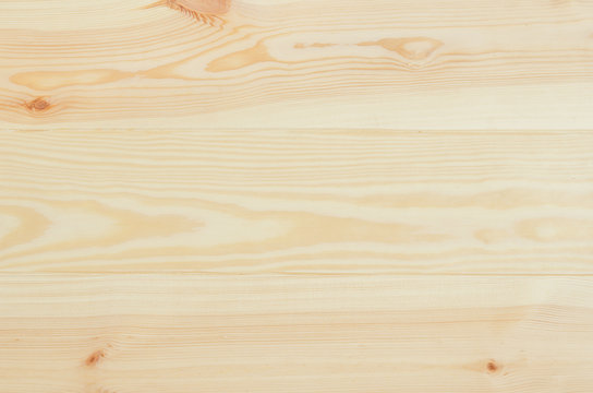 Fresh knotted pine wood planks background top view. Visible texture with natural patterns.