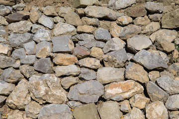 Unshaped Brick wall in the park. Stone wall.