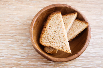Куски ржаного домашнего хлеба в деревянной тарелке